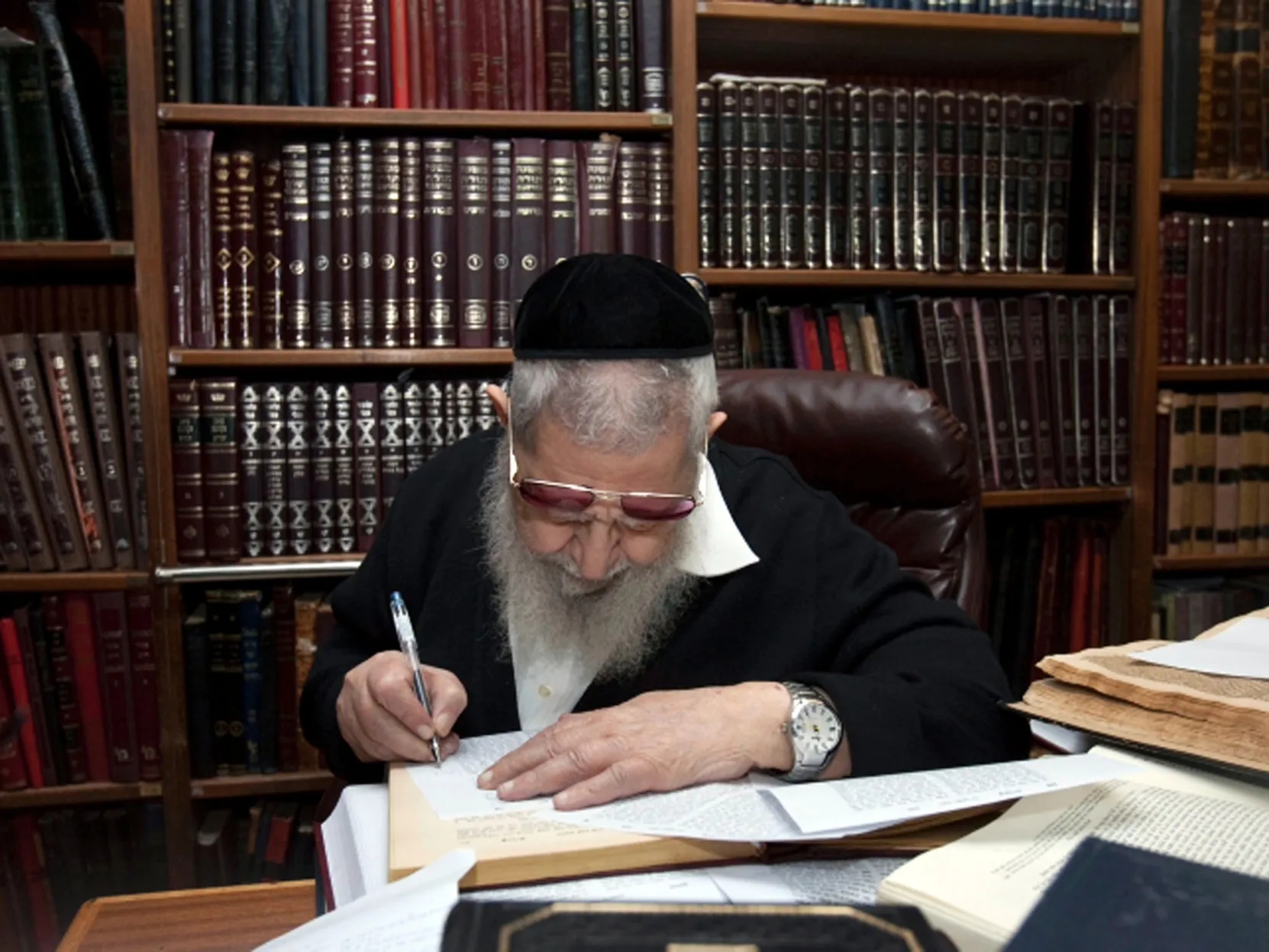 Maran writing among his books